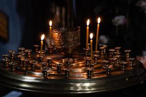 Iglesia velas quemar en un candelero en contra el fondo de íconos foto