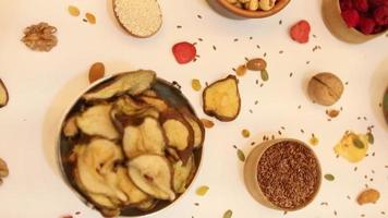 Healthy vegetarian food concept. Assortment of dried fruits, nuts and seeds on white background. Top view. video