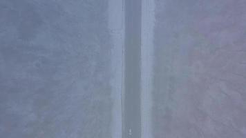 Aerial view on car driving through winter forest road. Scenic winter landscape video