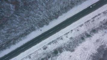 Antenne Aussicht auf Auto Fahren durch Winter Wald Straße. szenisch Winter Landschaft video