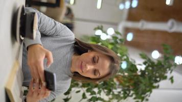 lindo mulher gasta dela Tempo dentro uma cafeteria usando Smartphone e bebendo café video