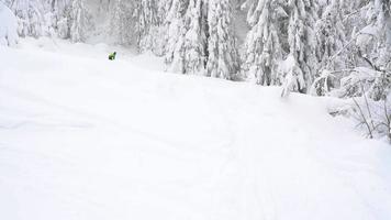 Visão a partir de altura para homem é equitação uma snowboard em uma coberto de neve campo em uma cabo atrás uma carro video