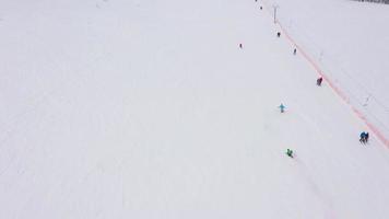 se från höjd till man är ridning en snowboard på en snötäckt fält på en kabel- Bakom en bil video