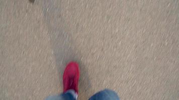 Top view of men's legs in red sneakers walking on wet asphalt video