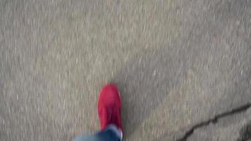 parte superior ver de de los hombres piernas en rojo zapatillas caminando en mojado asfalto video