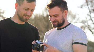 jovem gay casal levando foto do eles mesmos em uma filme Câmera dentro a Primavera tarde video