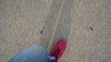 Top view of men's legs in red sneakers walking on wet asphalt video