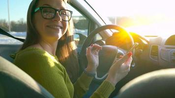 femme dans des lunettes en utilisant une téléphone intelligent dans le voiture video