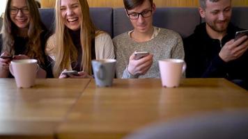 Gruppe von Menschen verwenden Handy, Mobiltelefon Telefone im ein Cafe stattdessen von kommunizieren mit jeder andere video