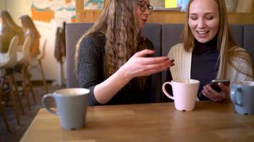 grupo de personas utilizar móvil Los telefonos en un café en lugar de comunicado con cada otro video