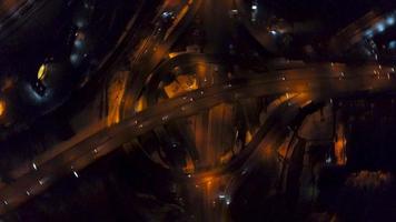 vertical parte superior abajo aéreo ver de tráfico en autopista intercambio a noche video