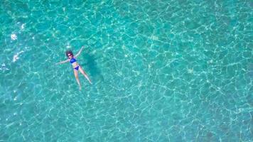 Relaxed beautiful girl lies on her back in the summer sea video