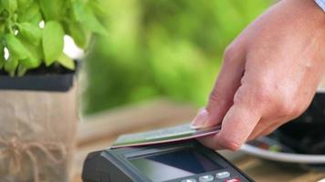 NFC credit card payment. Woman paying with contactless credit card with NFC technology. Wireless money transaction video