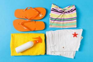 Flat lay composition with Beach accessories on blue color background. Summer holiday background. Vacation and travel items top view photo