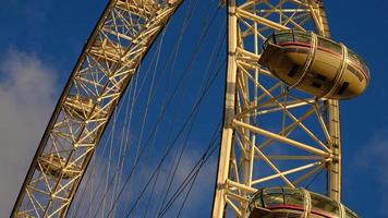 ferris rueda en el diversión parque en antecedentes de azul cielo con nubes bajo ángulo ver de un grande ferris rueda. foto