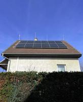 Home solar panel. Alternative energy is used for heating and water heating. Eco-friendly alternative energy for house. Residential family house suburban. Brown tile roof of home with solar panels. photo