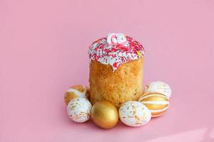 Pascua de Resurrección pasteles - tradicional kulich y dorado huevos en un rosado antecedentes. paska Pascua de Resurrección un pan en ruso letras xb foto