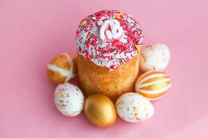 Easter Cakes - Traditional Kulich and golden eggs on  pink background. Paska Easter Bread in Russian letters XB photo