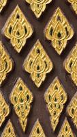 Pattern of gold flower carved on stucco design of native wall, Thai style in temple photo