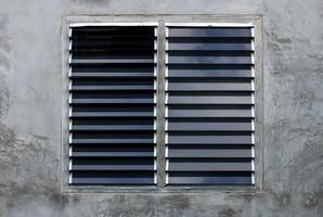 Louver window on gray concrete wall photo