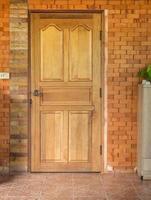 wooden door in brick wall background at home photo