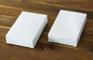 blanco blanco cartulina paquete caja Bosquejo en oscuro de madera mesa foto