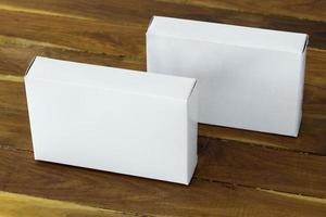 blanco blanco cartulina paquete caja Bosquejo en oscuro de madera mesa foto