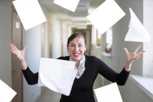 un mujer en el oficina dispersa documentos. nervioso empleado. foto