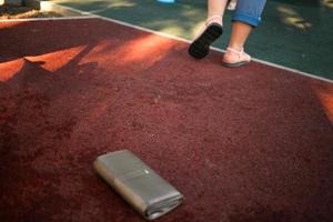 The woman lost her leather wallet with money on the street. Close-up of a wallet lying on the sidewalk. photo