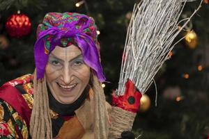 baba yaga con un Escoba en el antecedentes de el Navidad árbol.ruso bruja. foto