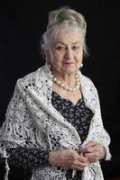 Portrait of a ninety year old woman. Beautiful old lady. Luxurious grandmother on a black background. Elderly beauty. The gray-haired well-groomed pensioner. photo