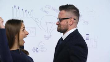 Mens en vrouw bespreken de bedrijf strategie voor succes in een modern glas kantoor video