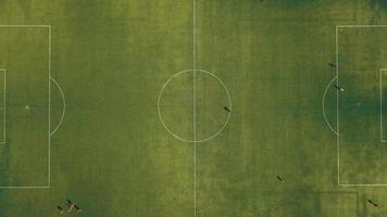 Aerial view of football team practicing at day on soccer field in top view video