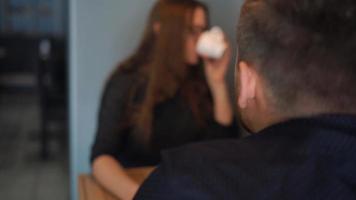 Young couple talking and drinking coffee in cafe video