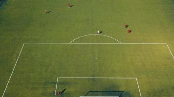Aerial view of football team practicing at day on soccer field in top view video