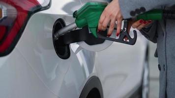 mujer inserta un combustible pistola en un gas tanque a repostar un coche video