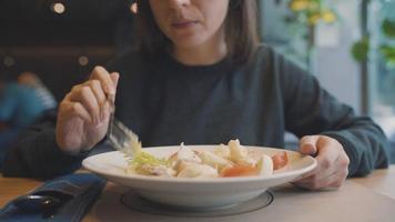 mujer comiendo César ensalada en un café video