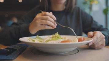 mujer comiendo César ensalada en un café video