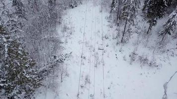 aéreo ver de esquí recurso - esquí levantar y cubierto de nieve conífero bosque. montes de Cárpatos, Ucrania video