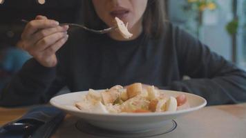 mulher comendo César salada dentro uma cafeteria video