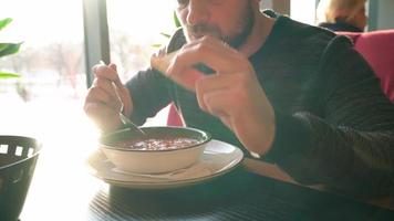 Man eats soup and bread in a restaurant video