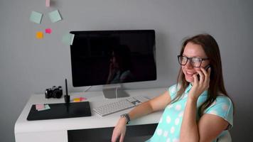 casual gráfico diseñador hablando en el teléfono durante un descanso en creativo oficina video