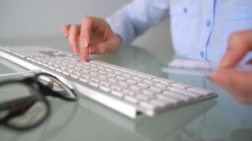 mujer paga por crédito tarjeta compras en el Internet. mujer oficina trabajador mecanografía en el teclado. en línea pago concepto video