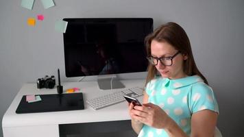 casual gráfico diseñador hablando en el teléfono durante un descanso en creativo oficina video