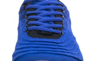 Part of a blue sneaker made of fabric with laces. A fragment of sports shoes. photo