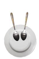 Plate with spoons on a white background. Funny dishes. Plate with a smile. photo