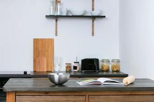 The interior of a simple kitchen. Kitchen table with a bowl and a book. photo