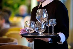 Hands hold a tray with glasses. Waiter in a restaurant. photo