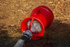 Fire hose with water on the ground. Fire extinguishing photo