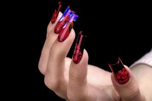 Hand with a beautiful manicure on a black background. Nail design. Extended nails. photo